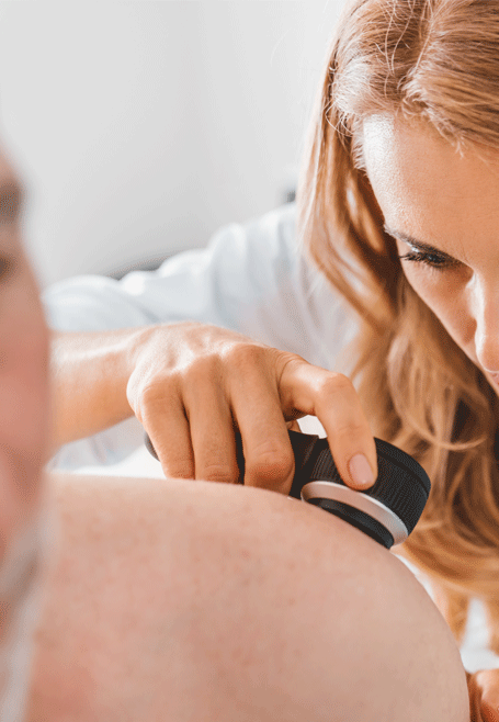 Photo of a doctor using a dermatoscope on a patient